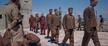 Movie still from “Exodus” (1960), directed by Otto Preminger – A number of men in brown clothing walking on a brick path; Wide shot, High angle