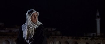 Movie still from “Exodus” (1960), directed by Otto Preminger – A man wearing a robe standing in front of a wall; Medium shot, Low angle