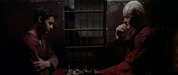 Movie still from “Exodus” (1960), directed by Otto Preminger – Two men are playing a game of chess in a jail cell; Medium shot, High angle