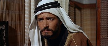 Movie still from “Exodus” (1960), directed by Otto Preminger – A person with a beard wearing a headdress; Close Up shot, High angle