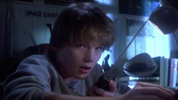 Movie still from “Explorers” (1985), directed by Joe Dante – A young man holding a cell phone up to his ear; Close Up shot, Low angle
