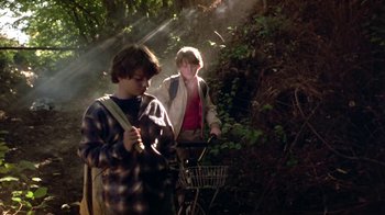 Movie still from “Explorers” (1985), directed by Joe Dante – Two young men are walking through the woods; Medium shot, Low angle