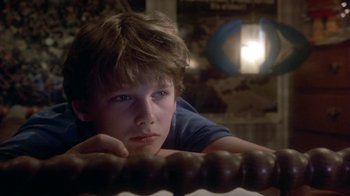 Movie still from “Explorers” (1985), directed by Joe Dante – A young man leaning on a railing in front of a building; Close Up shot, Low angle
