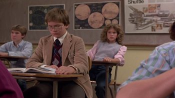 Movie still from “Explorers” (1985), directed by Joe Dante – A man and a woman sitting at a table in a classroom; Medium shot, Over the shoulder angle