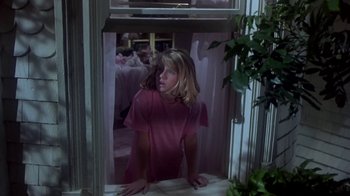 Movie still from “Explorers” (1985), directed by Joe Dante – A young girl looking out of a window at night; Medium shot, Low angle