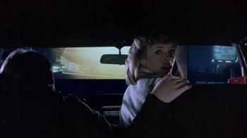 Movie still from “Explorers” (1985), directed by Joe Dante – A woman sitting in the driver's seat of a car at night; Medium shot, Low angle