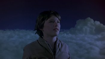 Movie still from “Explorers” (1985), directed by Joe Dante – A young boy is looking up into the sky; Medium shot, Low angle
