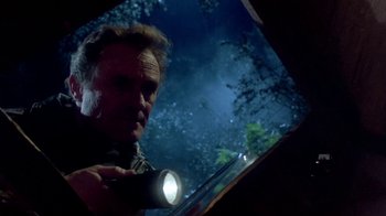 Movie still from “Explorers” (1985), directed by Joe Dante – A man holding a flashlight in front of a mirror; Close Up shot, Low angle