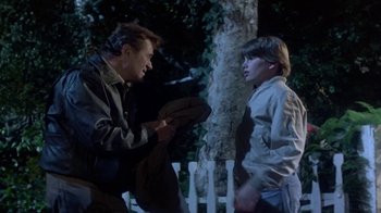 Movie still from “Explorers” (1985), directed by Joe Dante – A man talking to a young boy in a park; Medium shot, Over the shoulder angle