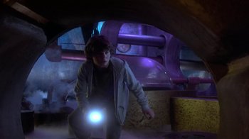 Movie still from “Explorers” (1985), directed by Joe Dante – A person holding a flashlight in a room; Medium shot, Low angle