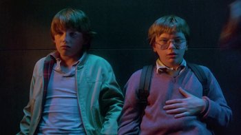 Movie still from “Explorers” (1985), directed by Joe Dante – Two young men standing next to each other in front of a wall; Medium shot, Low angle