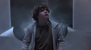 Movie still from “Explorers” (1985), directed by Joe Dante – A young man standing in front of a cloudy sky; Medium shot, Low angle