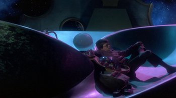 Movie still from “Explorers” (1985), directed by Joe Dante – A woman sitting in a tub with a bowl of candy; Wide shot, High angle