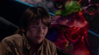 Movie still from “Explorers” (1985), directed by Joe Dante – A young boy sitting in front of a colorful background; Close Up shot, Over the shoulder angle