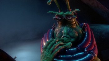 Movie still from “Explorers” (1985), directed by Joe Dante – A green creature sitting in a chair; Close Up shot, High angle