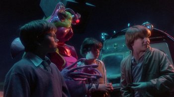 Movie still from “Explorers” (1985), directed by Joe Dante – A group of people standing next to each other in a room; Medium shot, Over the shoulder angle