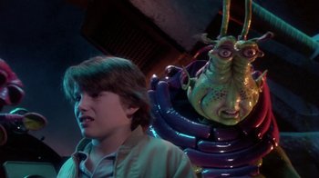 Movie still from “Explorers” (1985), directed by Joe Dante – A young boy standing next to a statue of an insect; Close Up shot, Low angle