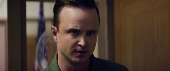 Movie still from “Eye in the Sky” (2015), directed by Gavin Hood – A person wearing a green shirt; Close Up shot, Over the shoulder angle