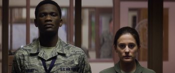 Movie still from “Eye in the Sky” (2015), directed by Gavin Hood – A man and a woman standing next to each other; Medium shot, Low angle