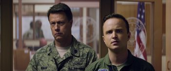 Movie still from “Eye in the Sky” (2015), directed by Gavin Hood – Two men in military fatigues standing next to each other; Close Up shot, Over the shoulder angle
