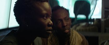 Movie still from “Eye in the Sky” (2015), directed by Gavin Hood – Two men sitting next to each other on a bus; Close Up shot, Over the shoulder angle