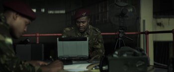 Movie still from “Eye in the Sky” (2015), directed by Gavin Hood – A man in a military uniform looking at a computer screen; Medium shot, Over the shoulder angle