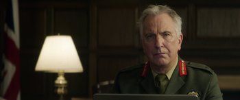 Movie still from “Eye in the Sky” (2015), directed by Gavin Hood – An older man wearing a uniform looking at the camera; Close Up shot, Low angle