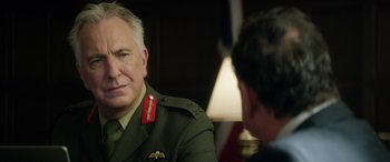 Movie still from “Eye in the Sky” (2015), directed by Gavin Hood – A man in a military uniform talking to another man in a military uniform; Close Up shot, Over the shoulder angle