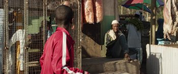 Movie still from “Eye in the Sky” (2015), directed by Gavin Hood – A man sitting in front of a mirror next to a boy; Medium shot, Over the shoulder angle