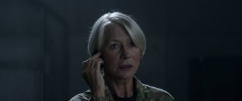 Movie still from “Eye in the Sky” (2015), directed by Gavin Hood – An older woman talking on a cell phone; Close Up shot, Over the shoulder angle