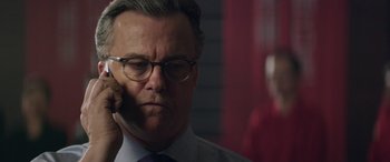 Movie still from “Eye in the Sky” (2015), directed by Gavin Hood – An older man wearing glasses and a tie; Close Up shot, Low angle