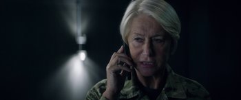 Movie still from “Eye in the Sky” (2015), directed by Gavin Hood – An older woman talking on a cell phone; Close Up shot, Low angle