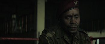 Movie still from “Eye in the Sky” (2015), directed by Gavin Hood – A man in a military uniform wearing a red hat; Close Up shot, Low angle