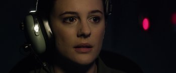 Movie still from “Eye in the Sky” (2015), directed by Gavin Hood – A person wearing headphones; Close Up shot, Over the shoulder angle