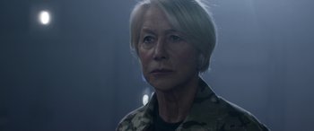 Movie still from “Eye in the Sky” (2015), directed by Gavin Hood – A person with short blonde hair; Close Up shot, Over the shoulder angle