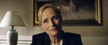 Movie still from “Eye in the Sky” (2015), directed by Gavin Hood – A person wearing a suit; Close Up shot, Over the shoulder angle