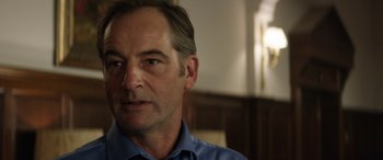 Movie still from “Eye in the Sky” (2015), directed by Gavin Hood – A person wearing a blue dress shirt; Close Up shot, Over the shoulder angle