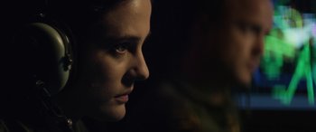 Movie still from “Eye in the Sky” (2015), directed by Gavin Hood – A person's face in the dark; Close Up shot, Over the shoulder angle