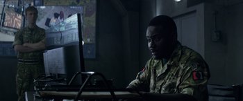 Movie still from “Eye in the Sky” (2015), directed by Gavin Hood – A man sitting in front of a computer monitor; Close Up shot, Over the shoulder angle