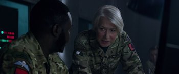 Movie still from “Eye in the Sky” (2015), directed by Gavin Hood – A woman in a military uniform talking to a man in fatigues; Close Up shot, Over the shoulder angle