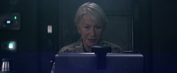 Movie still from “Eye in the Sky” (2015), directed by Gavin Hood – An older woman sitting in front of a computer monitor; Close Up shot, Over the shoulder angle