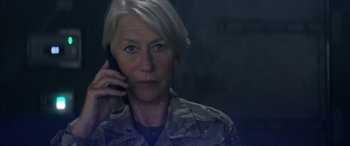 Movie still from “Eye in the Sky” (2015), directed by Gavin Hood – An older woman is talking on a cell phone; Close Up shot, Low angle