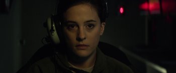 Movie still from “Eye in the Sky” (2015), directed by Gavin Hood – A person with headphones on looking into the distance; Close Up shot, Over the shoulder angle