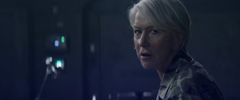 Movie still from “Eye in the Sky” (2015), directed by Gavin Hood – An older woman with white hair looking at the camera; Close Up shot, Over the shoulder angle