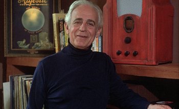 Movie still from “F for Fake” (1973), directed by François Reichenbach – An older man sitting in front of an old radio; Close Up shot, Low angle