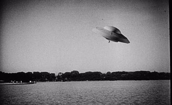 Movie still from “F for Fake” (1973), directed by François Reichenbach – An image of an unidentified flying object flying over a body of water; Extreme Wide shot, Low angle