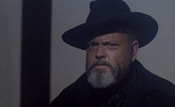 Movie still from “F for Fake” (1973), directed by François Reichenbach – A man with a beard wearing a black hat; Close Up shot, Low angle