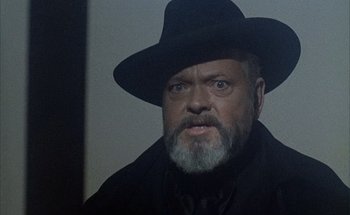 Movie still from “F for Fake” (1973), directed by François Reichenbach – A man with a beard wearing a black hat; Close Up shot, Low angle