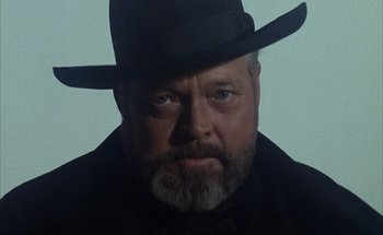 Movie still from “F for Fake” (1973), directed by François Reichenbach – A man with a beard wearing a black hat; Close Up shot, Low angle