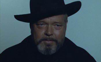 Movie still from “F for Fake” (1973), directed by François Reichenbach – A man with a beard wearing a black hat; Close Up shot, Low angle